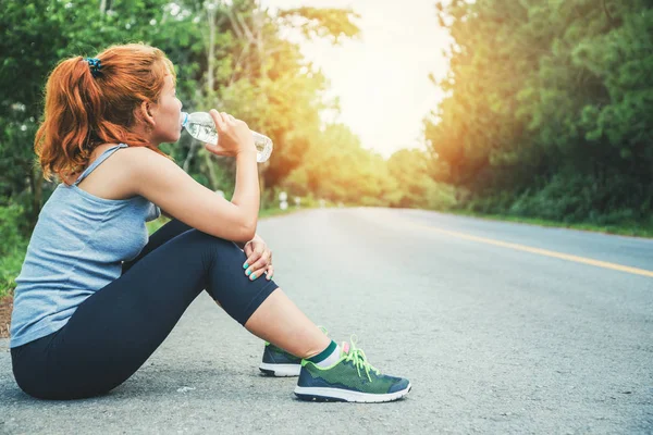 Kadınlar sokakta egzersiz yapar. Doğa parkı. Sağlıklı su için. Asyalı kadınlar