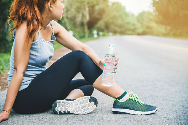 Women exercise on the street. Nature park. Drink healthy water. Asian women