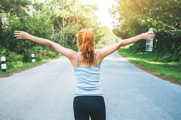 Kadınlar sokakta egzersiz yapar. Doğa parkı. Sağlıklı su için. Asyalı kadınlar