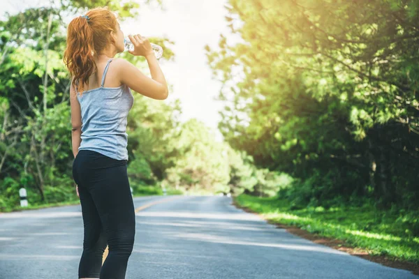 Kadınlar sokakta egzersiz yapar. Doğa parkı. Sağlıklı su için. Asyalı kadınlar