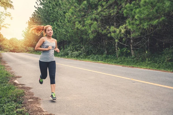 Le donne si esercitano a correre per strada. Parco naturale. Donne asiatiche — Foto Stock