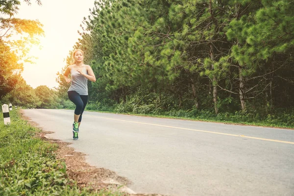 Le donne si esercitano a correre per strada. Parco naturale. Donne asiatiche — Foto Stock