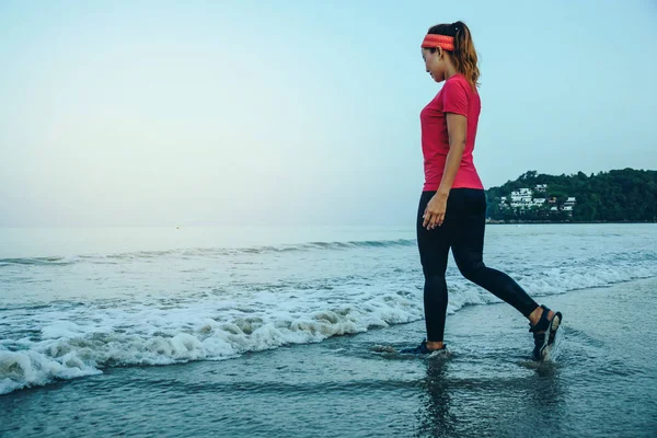 Allenamento di jogging femminile sulla spiaggia al mattino. Rilassati con la passeggiata sul mare. in estate — Foto Stock