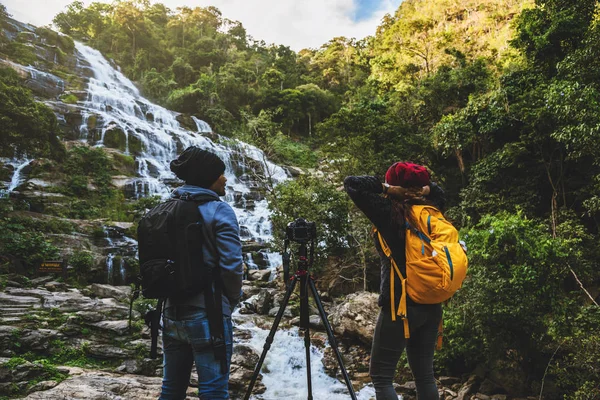 couples travel relax to photograph the waterfalls beautiful. In the winter. at the waterfall mae ya chiangmai in thailand. travel nature. summer