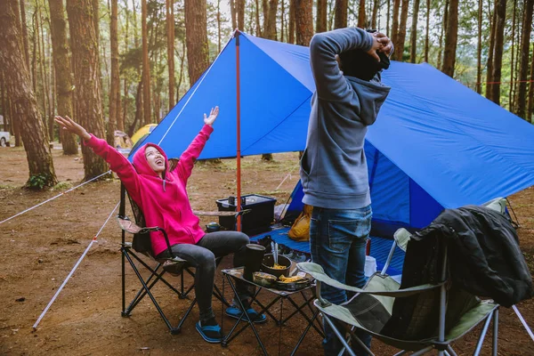 Jovem casal asiático de feliz apreciando Acampar na floresta de pinheiros Sente-se e coma comida na página Camping no meio da natureza . — Fotografia de Stock