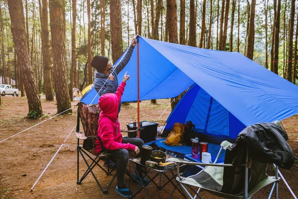 Genç Asyalı mutlu bir çift çam ormanında kamp yapıyor ve doğanın ortasında kamp sayfasında yemek yiyorlar.. — Stok fotoğraf