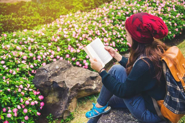 여자는 꽃 정원에서 자연을 여행. 도이 인타논에서 바위에 앉아 책을 읽고 휴식을 취하십시오.. — 스톡 사진