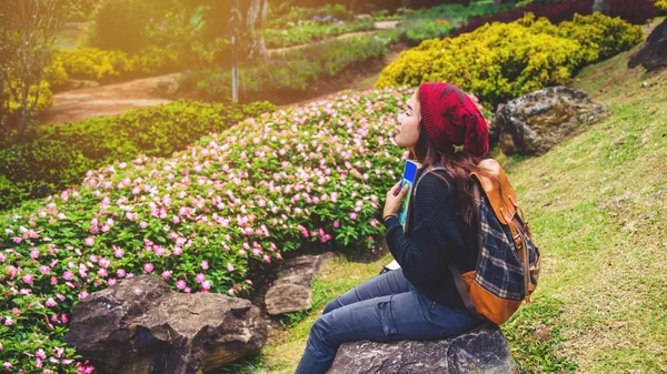 여자는 꽃 정원에서 자연을 여행. 도이 인타논에서 바위에 앉아 책을 읽고 휴식을 취하십시오.. — 스톡 사진