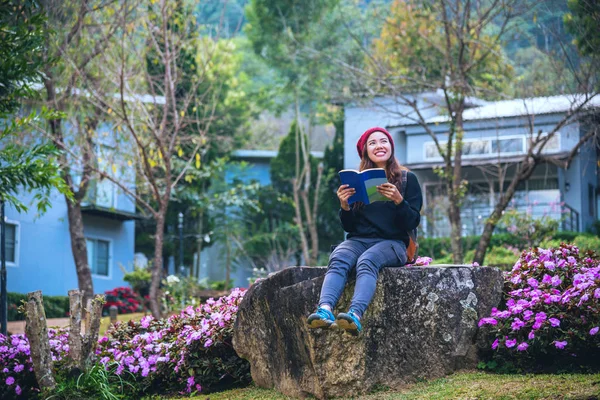 Žena cestuje v květinové zahradě. relaxovat sedět na skalách a číst knihy uprostřed přírody v národním parku Doi Inthanon. — Stock fotografie
