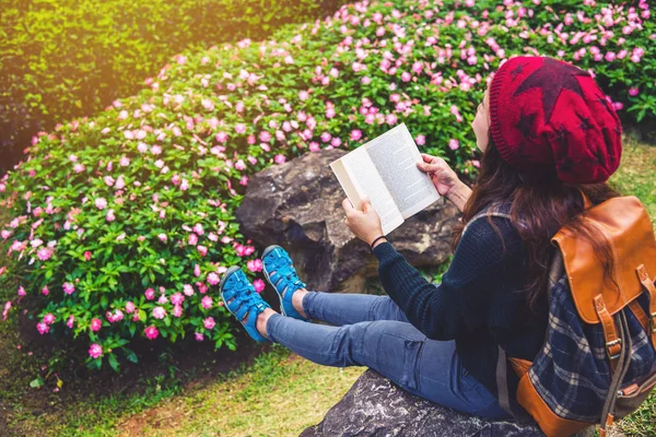여자는 꽃 정원에서 자연을 여행. 국립공원 도이 인타논(Doi Inthanon)의 자연 속에서 바위에 앉아 책을 읽으며 휴식을 취하세요.. — 스톡 사진