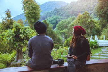 Asya çift seyahat fotoğraf doğa eğitim. Doğa dinlenmek ve çalışma bir kitap okumak. kamu parkında. Tayland 'da