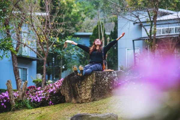 Žena cestuje v květinové zahradě. relaxovat sedět na skalách a číst knihy uprostřed přírody na Doi Inthanon. — Stock fotografie