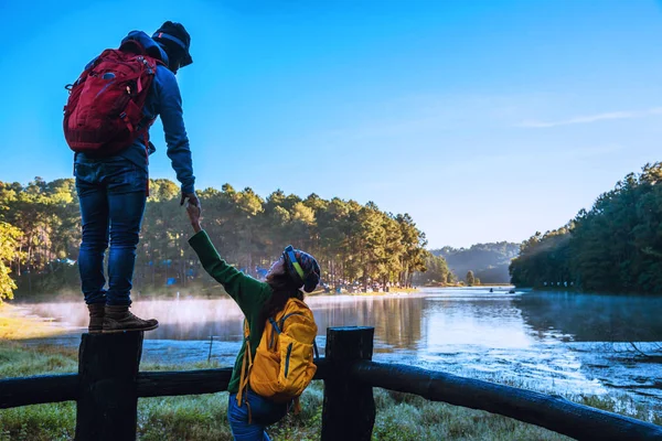 Unga par glada Njuta av naturturism, titta på den vackra sjön. — Stockfoto