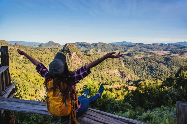 Jonge vrouw Toeristen met rugzakken blij om te reizen Ze stak haar handen op en geniet van de natuur landschap uitzicht. — Stockfoto