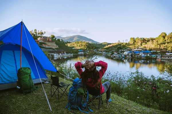 Aziatische vrouw reist door de natuur. Reizen ontspannen, Kamperen in een landelijk dorp op de berg, in de buurt van het meer. — Stockfoto