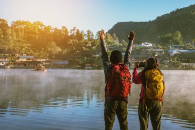 Asyalı bir çift, sabahları gölde sislerin yükselmesini seyrediyorlar. Seyahat Ban Rak Tayland köyü, Mae Hong Son Tayland. Gölün resmini çek.
