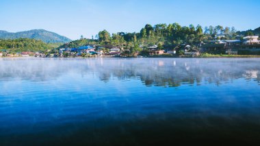 Sabahleyin Tayland 'daki Ban Rak Tayland köyünde gölün yüzeyinden yükselen sisin güzelliği.