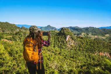 Bakış açısında duran kadın. Dağların doğal güzelliklerini çekmenin tadını çıkar..