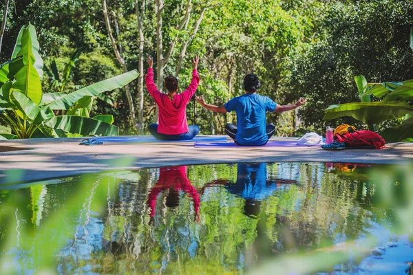 Asian woman and Asian man travel nature. Travel relax. Yoga posture concept, Good health care with yoga postures. Outdoor exercise Relax yoga.