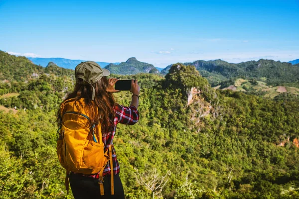 La mujer de pie en el punto de vista. Disfruta fotografiando la belleza natural de las montañas . — Foto de Stock