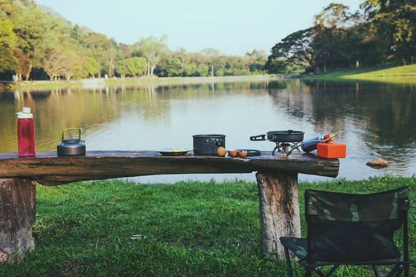 O fundo do pote e piquenique de gás que é colocado sobre a mesa de madeira. Acampar, piquenique, cozinhar, comer junto ao lago . — Fotografia de Stock