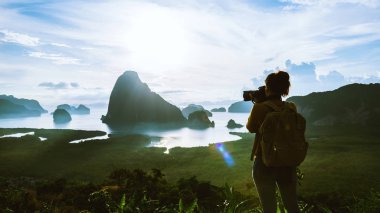 Young woman travels to take pictures of nature on the mountain. Travel adventure. Landscape Beautiful Mountain on sea at Samet Nangshe Viewpoint. Phang Nga Bay, Travel Thailand, summer holiday.