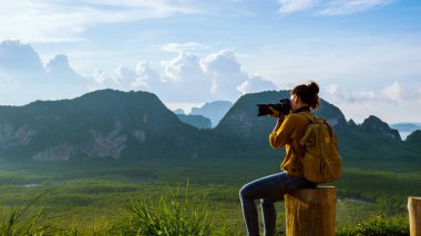 Genç kadın dağda doğanın fotoğraflarını çekmek için seyahat eder. Seyahat macerası. Samet Nangshe Manzarası 'nda deniz manzaralı güzel bir dağ. Phang Nga Körfezi, Tayland seferi, yaz tatili..