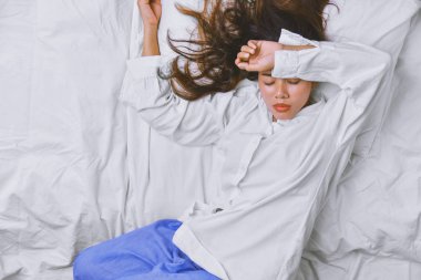 Yatakta Uyuyan Genç Kadın. Ama şiddetli karın ağrısından kaynaklanan uykusuzluk. Insomnia neden olur, İnsanlar uyur, gözler kapalı, hastalık, hastalık, hastalık, baş ağrısı, gerginlik.