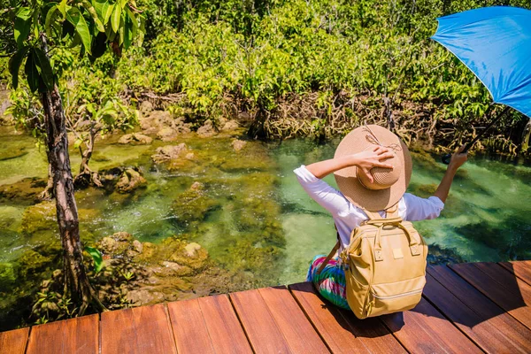 Asijské ženy cestují relaxovat, cestovat příroda v prázdninách. ženy si užívají sezení a sledování přírody jezerního lesa v Tha-pom-klong-song-nam v krabi. léto, Travel Thailand. — Stock fotografie