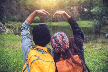 Çiftler seyahat eder, dinlenir, kışın doğayı izlerler. Paphiopedilum orkide koruma merkezi, Chiangmai 'de.