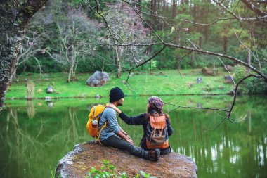 Çiftler seyahat eder, dinlenir, kışın doğayı izlerler. Paphiopedilum orkide koruma merkezi, Chiangmai 'de.