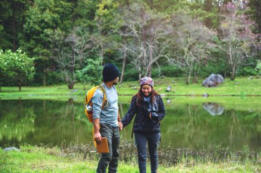 Asyalı çiftler, tatilde rahatlayın. seyahat doğası fotoğraf çekiyor pembe sakura.