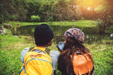 Çiftler seyahat eder, dinlenir, kışın doğayı izlerler. Paphiopedilum orkide koruma merkezi, Chiangmai 'de.