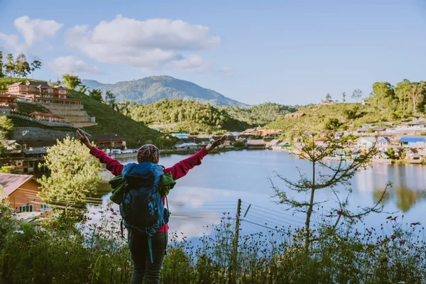 Meisje met rugzak staan kijken uit naar een prachtig uitzicht in het meer. Toeristische reiziger op zoek naar zonlicht op de bergen. Theeplantage in Mae Hong Son. — Stockfoto