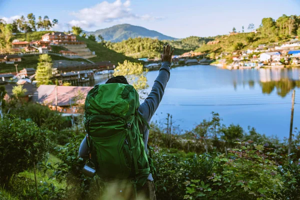 Asijský muž cestuje přírodou. Travel relax, Kempování ve venkovské vesnici na hoře, v blízkosti jezera. — Stock fotografie