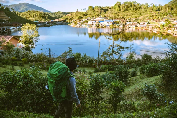 Asijský muž cestuje přírodou. Travel relax, Kempování ve venkovské vesnici na hoře, v blízkosti jezera. — Stock fotografie