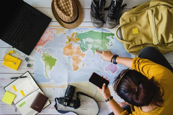 Vakantieplanning concept met kaart. Bovenaanzicht van apparatuur voor reizigers. Travel concept achtergrond, Jonge vrouw wijst naar de kaart India. — Stockfoto