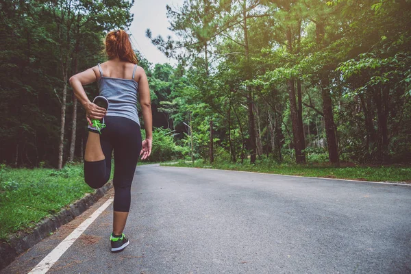 Жінки вправляються на вулиці. Природний парк. Дівчинка, яка піднімає ноги на тренування. вправи, біг . — стокове фото
