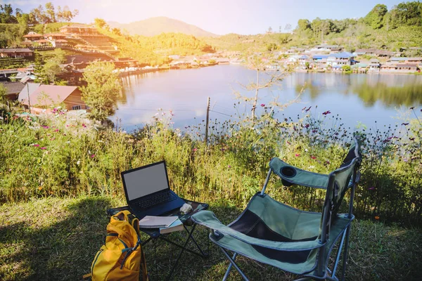 Adventures Camping and And use a working notebook near lake, Concept Travel, Camping Ban Rak Thai village Mae Hong Son in Thailand.