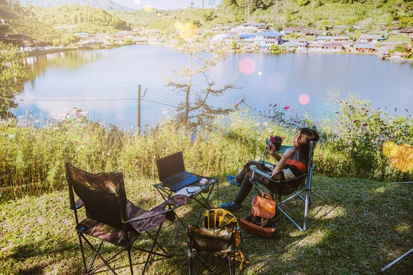 Aziatische vrouwelijke toeristen kamperen en En werken notebook, Ze is gelukkig, ontspannen, genieten van het lezen van een boek. — Stockfoto