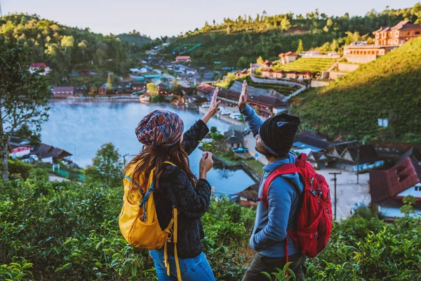 Een paar Aziaten die samen op het platteland op de berg reizen. Genieten van een kijkje bij zonsondergang, Romantische koppels. — Stockfoto