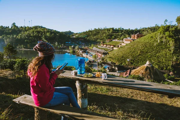 A rapariga viaja na montanha. Ela está assistindo a paisagem bonita da aldeia tailandesa Ban Rak, Beba café e coma comida, lanche pela manhã . — Fotografia de Stock