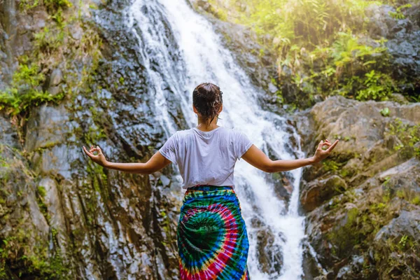 As mulheres asiáticas relaxam nas férias. Jogar se ioga. Jogue se ioga na cachoeira no Moutain. exercício, boa saúde, viajar natureza, Viajar relaxar. Viagem Tailândia. (Huai Toh cachoeira  ) — Fotografia de Stock