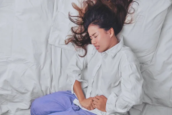 Young Woman Sleeping In Bed. But insomnia caused by Severe abdominal pain. Insomnia caused, People Sleep, Eyes closed, Disease, painful, get sick, deadly disease, Sickness, sick. — Stock Photo, Image