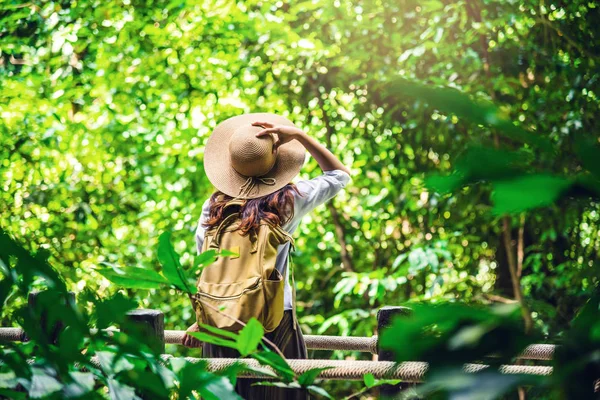 Ženy cestují relaxovat přírodu v prázdninách. Studium přírody v lese. The Girl happy walking and enjoying Tourism in through the forest. — Stock fotografie