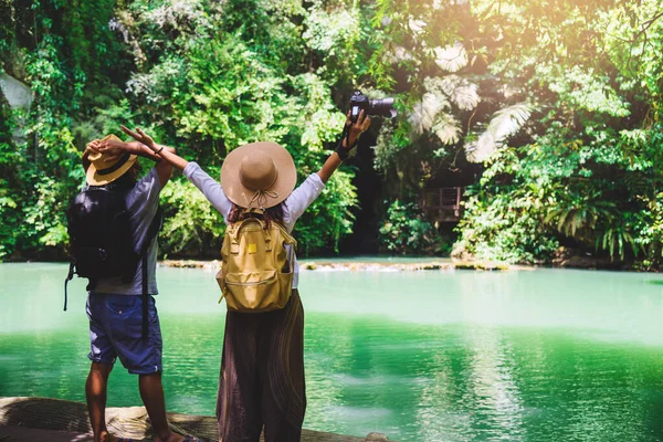 Parejas de viaje con mochilas de viaje naturales durante las vacaciones. Parejas viajando, relajándose en la selva verde y disfrutando del hermoso estanque Esmeralda. Turismo senderismo estudio de la naturaleza . —  Fotos de Stock