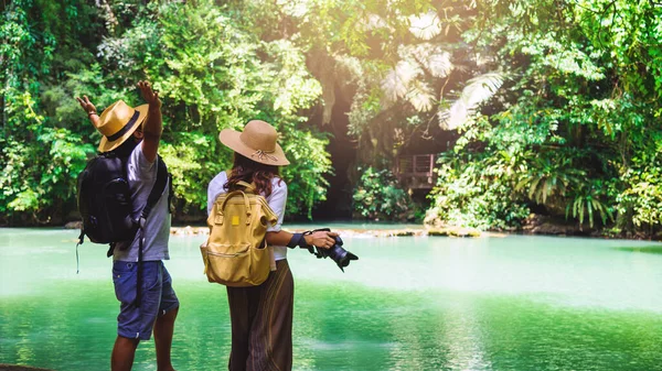 Cestovní páry s přírodními cestovními batohy během prázdnin. Cestování párů, odpočinek v zelené džungli a požitek z krásného Smaragdového rybníka. Turistika turistika studium přírody. — Stock fotografie
