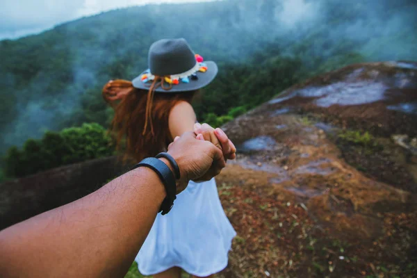 Couple Asian travel nature. Travel relax. happy and enjoying a beautiful nature on peak of foggy mountain. Lover women and men Hold hands running on the lawn. Wild nature wood on the mountain. — ストック写真