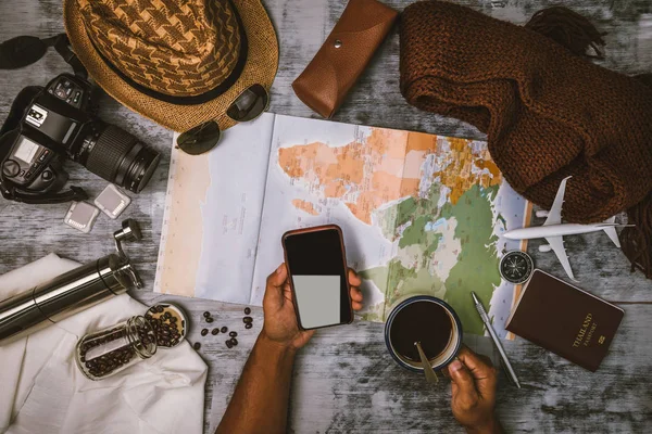 Turista planejamento de férias com a ajuda de mapa do mundo e bússola ao longo e xícara de café com moedor de café com outros acessórios de viagem. A preparar-se para viajar. Viagens planejamento conceito férias com mapa. Verão . — Fotografia de Stock