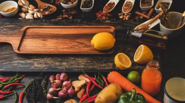 Ahşap zemin üzerinde pişirme malzemesi olarak kullanılacak baharatlar ve taze organik sebzeler. Sağlıklı bitkiler ve baharatlar. Köy tahtasında organik sebzeler.